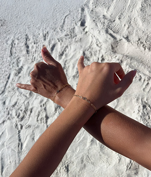 Four wrists adorned with rings and delicate bracelets